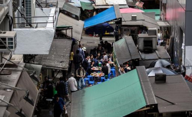 Hong Kong (AFP). A Hong Kong, les restaurants de rue s'accrochent à l'ombre des gratte-ciel 
