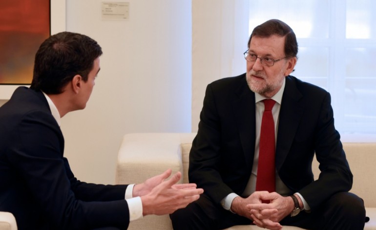 Madrid (AFP). Le Premier ministre espagnol Mariano Rajoy (d) s'exprime avec Pedro Sanchez, leader des socialites, le 23 décembre 2015 à Madrid