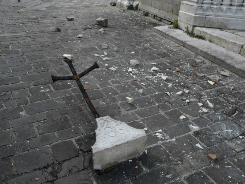 Une croix tombée pendant le séisme à Visso, dans le centre de l'Italie, le 27 octobre 2016 - TIZIANA FABI [AFP]