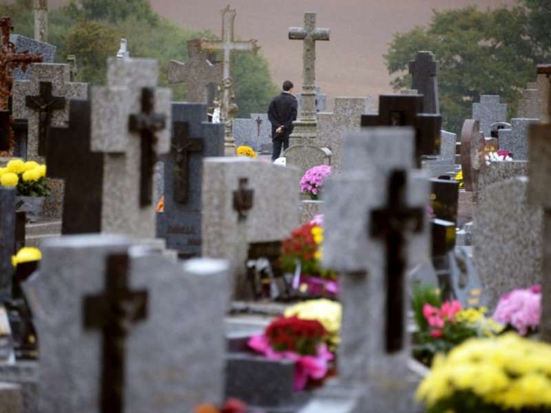 Un homme se recueille le 1er novembre 2013 dans le cimetière de Medreac - DAMIEN MEYER [AFP/Archives]