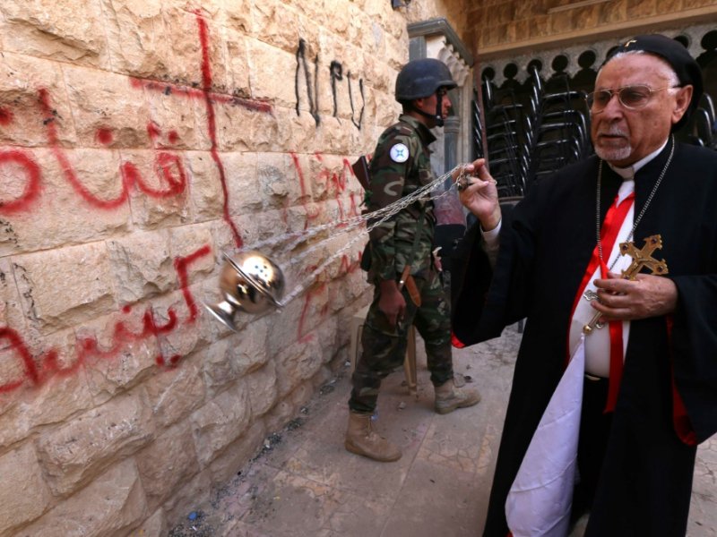 Petros Mouché, archevêque syriaque catholique de Mossoul et de Qaraqosh, inspecte les dégâts à Qaraqosh (30 km à l'est de Mossoul), le 30 octobre 2016 - SAFIN HAMED [AFP]