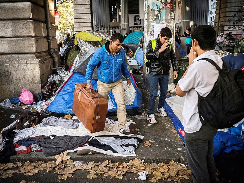 Des migrants transportent leurs effets personnels, lors  d'une opération policière sur le boulevard de la Villette à Paris, le 31 octobre 2016 - LIONEL BONAVENTURE [AFP]