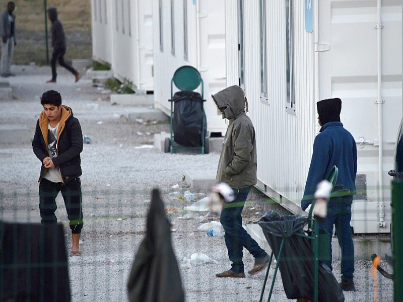 Des mineurs quittent l'enceinte du Centre d'accueil provisoire (CAP), composé de conteneurs, le 2 novembre 2016 à Calais - PHILIPPE HUGUEN [AFP]