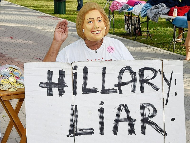 Un partisan de Donald Trump attaque Hillary Clinton sur ses mensonges avant un meeting électoral de son champion, le 2 novembre 2016 à Miami en Floride - RHONA WISE [AFP]