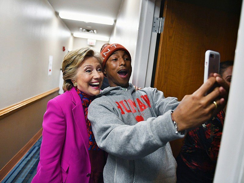 La candidate démocrate à la Maison Blanche Hillary Clinton pose pour un selfie avec le chanteur Pharrell Williams en marge d'un rassemblement de campagne à Raleigh, en Caroline du Nord, le 3 novembre 2016 - JEWEL SAMAD [AFP]