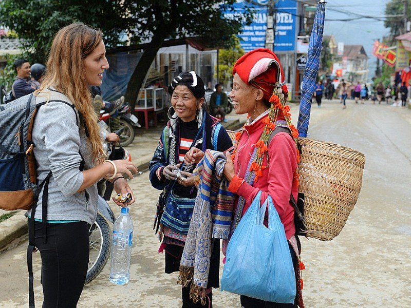 Des Vietnamiennes vendent des souvenirs à une touristes dans le village de Sapa, au Vietnam, le 1er octobre 2016 - HOANG DINH NAM [AFP]