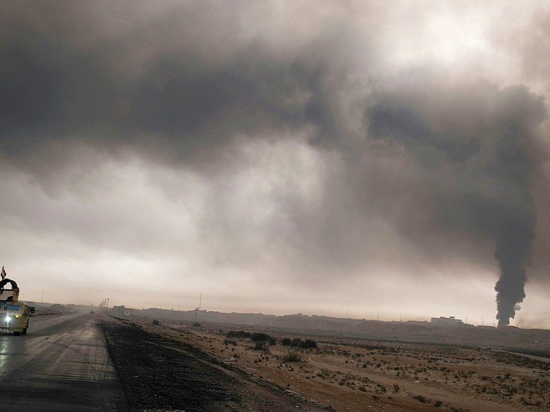 Un véhicule militaire irakien sur une route près de Qayyarah (sud de Mossoul), le 4 novembre  2016, sous un ciel noir envahi par la fumée des incendies de puits pétroliers - Ahmad MOUSA [AFP]