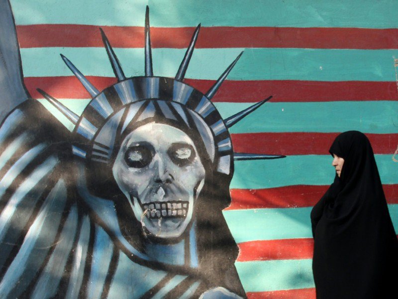 Une Iranienne passe devant une peinture murale sur la façade de l'ancienne ambassade américaine à Téhéran, le 9 novembre 2016 - ATTA KENARE [AFP]