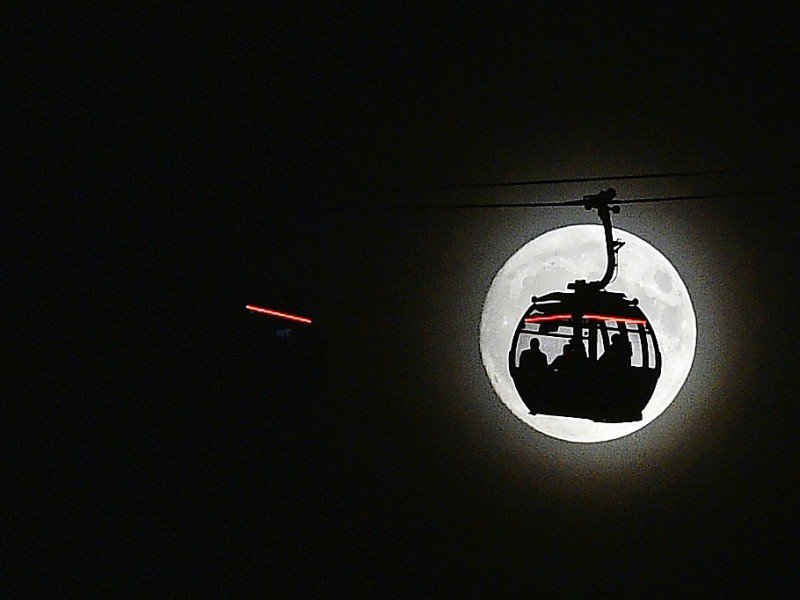 La lune vue derrière une cabine téléphérique de Londres, le 13 novembre 2016 - Glyn KIRK [AFP]
