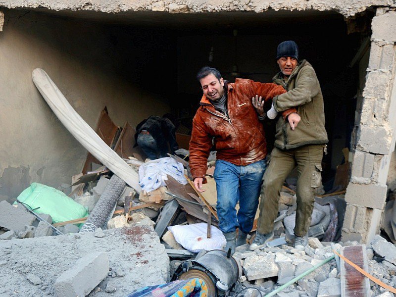 Deux syriens sortent des décombres d'un immeuble après des bombardements dans le quartier d'al-Hamra à Alep, tenu par les rebelles, le 20 novembre 2016 - THAER MOHAMMED [AFP]