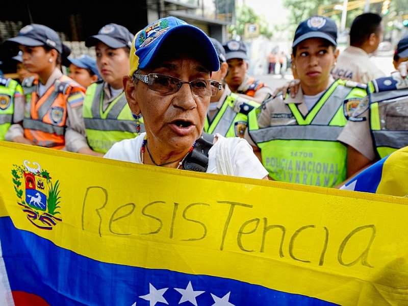 Un membre de l'opposition au président Nicolas Maduro porte un drapeau lors d'une manifestation à Caracas le 10 novembre 2016 - FEDERICO PARRA [AFP]