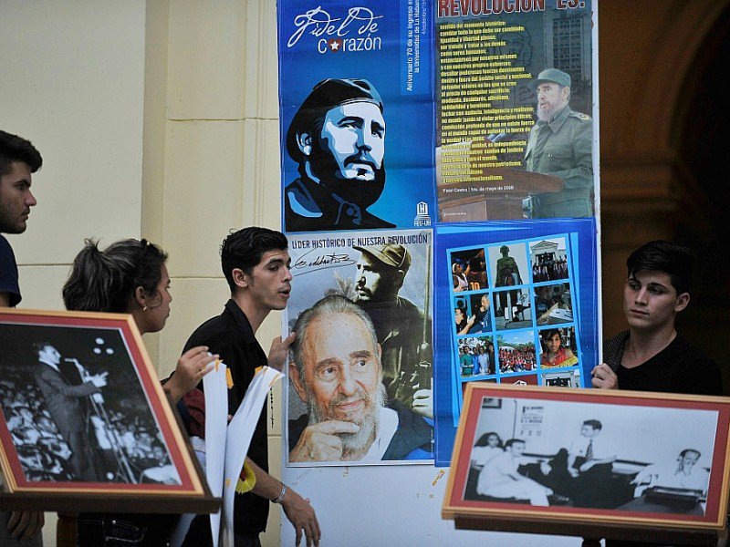 Des étudiants de La Havane ressortent les photos marquantes de la vie de Fidel castro, le 26 novembre 2016 - Yamil LAGE [AFP]