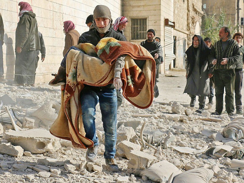 Un Syrien emporte le corps d'un enfant tué dans un bombardement  du quartier Bab al-Nairab le 24 novembre 2016 à Alep - AMEER ALHALBI [AFP]