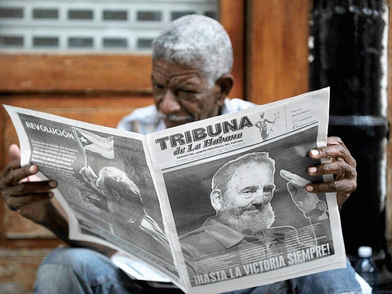 Un homme lit le journal, consacré à la mort de Fidel castro, dans les rues de La Havane le 27 novembre 2016 - PEDRO PARDO [AFP]