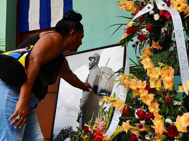 Une Cubaine se recueille devant une photo de Fidel Castro, le 28 novembre 2016 à La Havane - RONALDO SCHEMIDT [AFP]