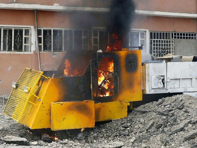 Un camion jaune rempli d'explosifs intacts en train de brûler le 30 novembre 2016 dans le quartier résidentiel d'al-Baker à Mossoul - THOMAS COEX [AFP]