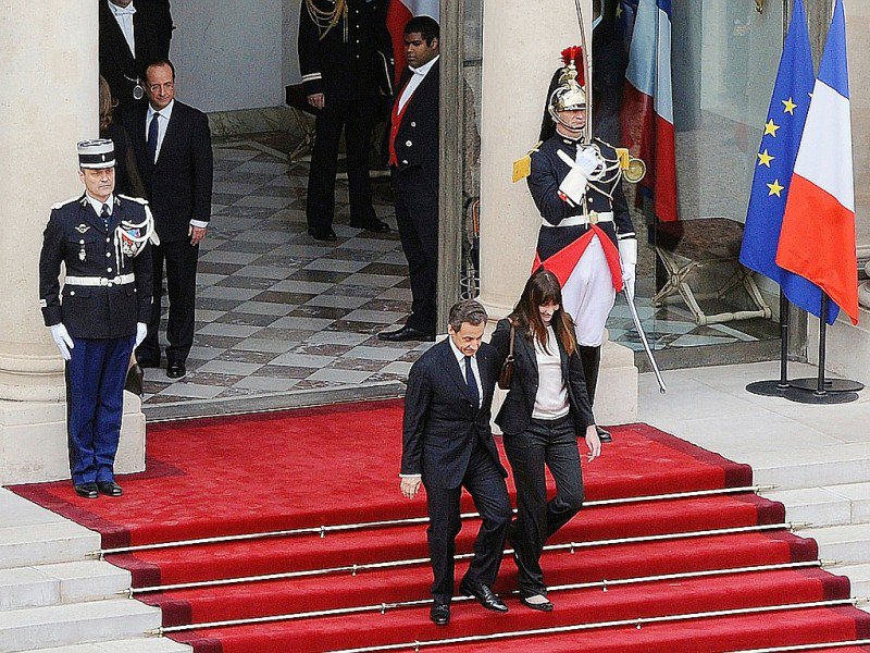 François Hollande regarde Nicolas Sarkozy et sa femme Carla Bruni-Sarkozy quitter l'Elysée le 15 mai 2012 à Paris - MEHDI FEDOUACH [AFP/Archives]
