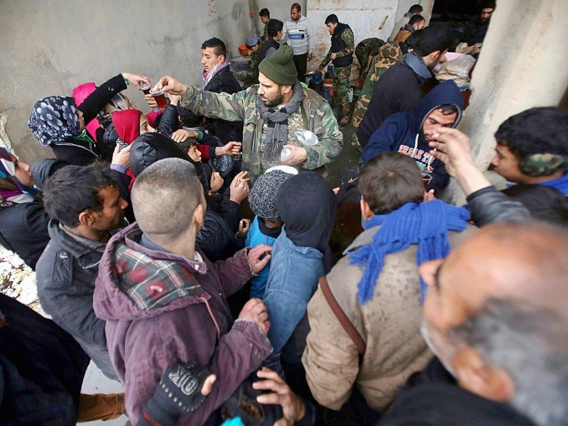 Des syriens font la queue pour recevoir à manger devant un centre gouvernemental accueillant les déplacés du fief rebelle d'Alep-Est à Jibrine, le 1er décembre 2016 - Youssef Karwashan [AFP]