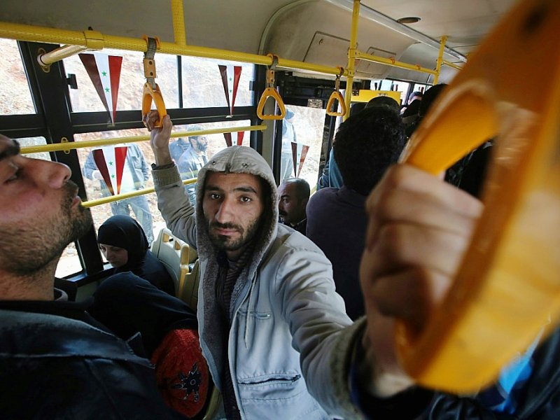 Des Syriens à bord d'un bus qui les conduit dans les anciens quartiers rebelles d'Alep, le 3 décembre 2016 - Youssef KARWASHAN [AFP]