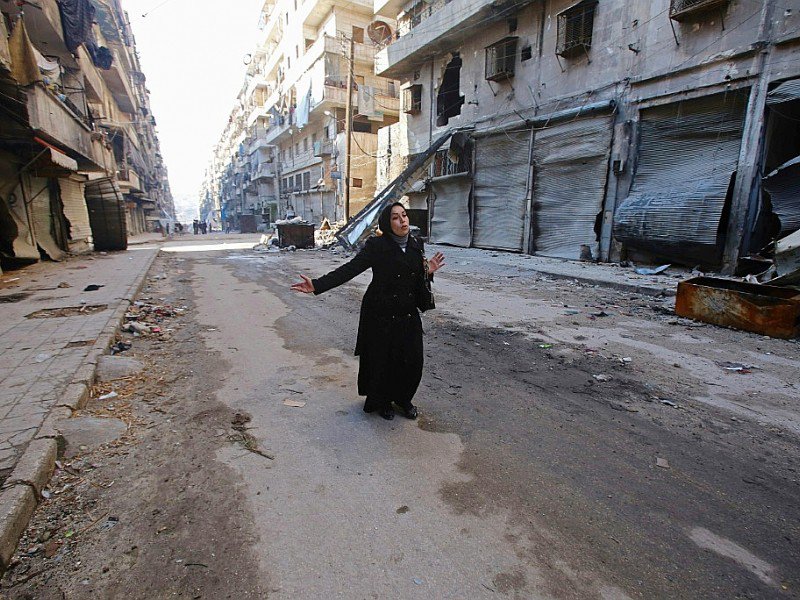 Une Syrienne à Alep dans le quartier dévasté où elle avait habité, le 4 décembre 2016 - Youssef KARWASHAN [AFP]
