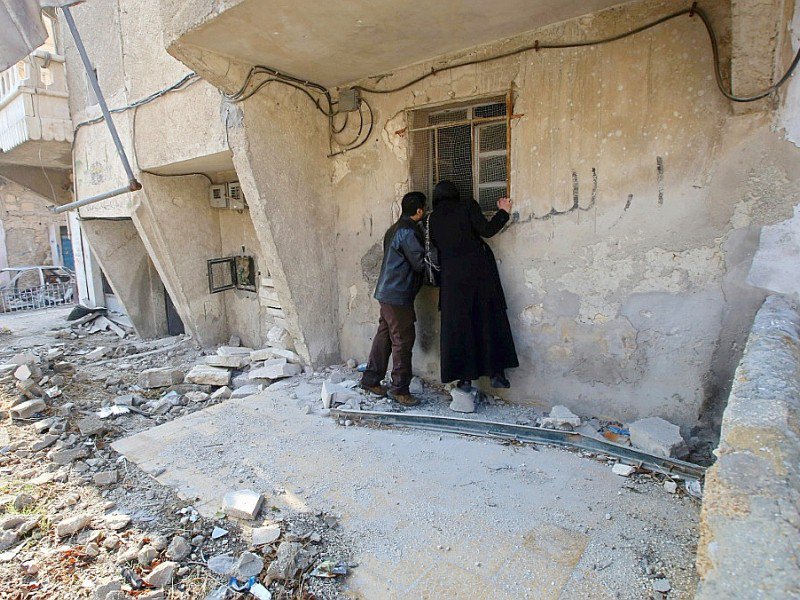 Un couple syrien devant leur maison dévastée à Alep, le 4 décembre 2016 - Youssef KARWASHAN [AFP]