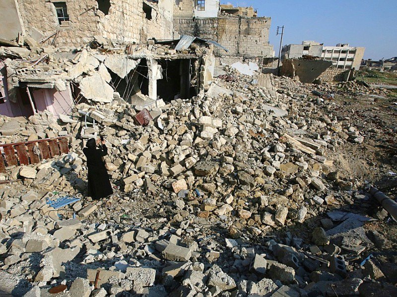 Une Syrienne photographie les ruines dans le quartier où elle avait habité, le 4 décembre 2016 à Alep, en Syrie - Youssef KARWASHAN [AFP]