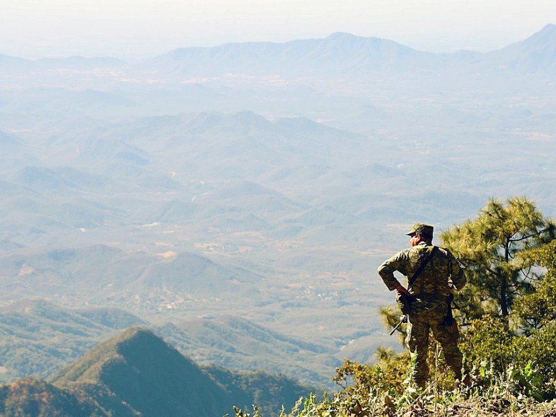 Un soldat mexicain regarde le paysage et les champs de pavots à opium dans la région montagneuse de l'Etat de Sinaloa, près de la localité de Surutato, le 8 décembre 2016 - ALFREDO ESTRELLA [AFP]