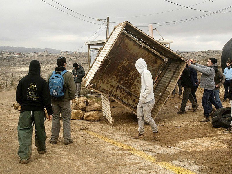 Des jeunes colons bloquent l'entrée de leur colonie Amona le 15 décembre 2016,  qui pourrait bientôt faire l'objet d'une évacuation car installée illégalement en Cisjordanie - JACK GUEZ [AFP]