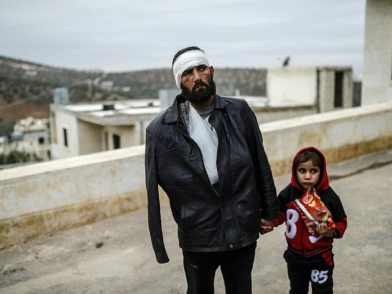 Un blessé syrien et sa fille attendent devant l'hôpital du poste frontière de Bab al-Hawa entre la Turquie et la Syrie, le 16 décembre 2016 - BULENT KILIC [AFP]