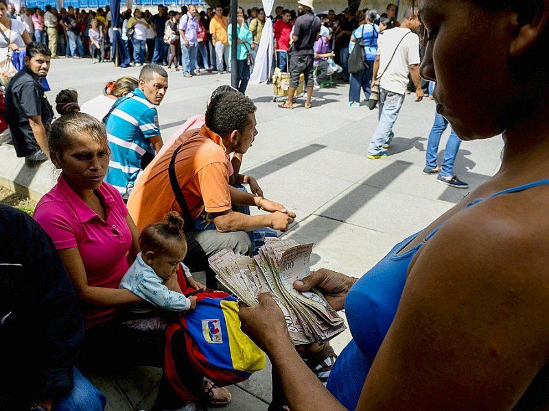 Des Vénézuéliens font la queue devant la banque centrale à Caracas pour changer leurs billets de 100 bolivars, le 16 décembre 2016 - FEDERICO PARRA [AFP]
