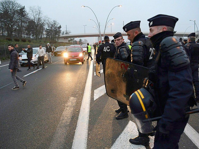 Des policiers déployés le 17 décembre sur l'autoroute menant à Orly, bloquée par des chauffeurs de VTC - Christophe ARCHAMBAULT [AFP]