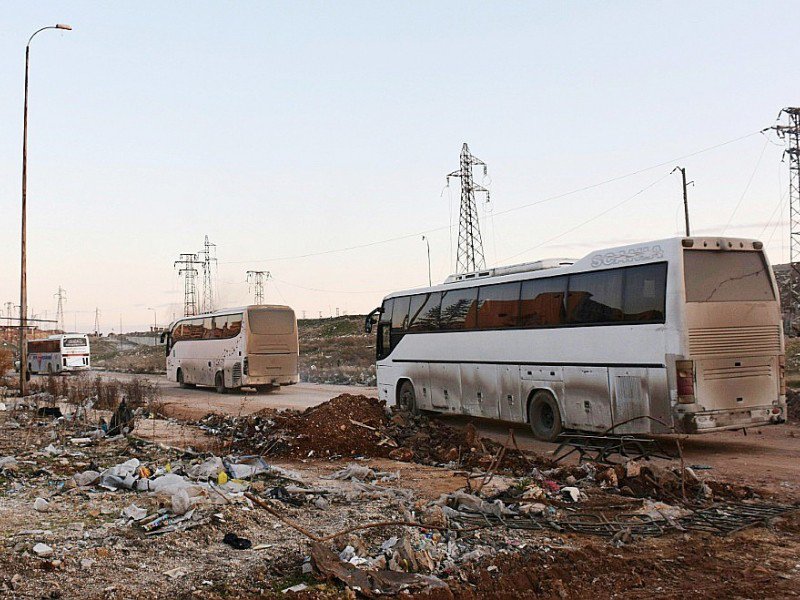 Des bus traversent  Ramoussa le 18 décembre 2016 dans la banlieue sud d'Alep - George OURFALIAN [AFP]