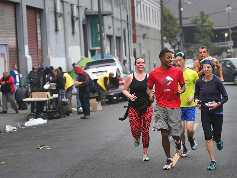 Des joggeurs du club Midnight Runners s'entraînent au petit matin dans les rues du quartier de Skid Row à Los Angeles, le 12 décembre 2016 - Mark RALSTON [AFP]