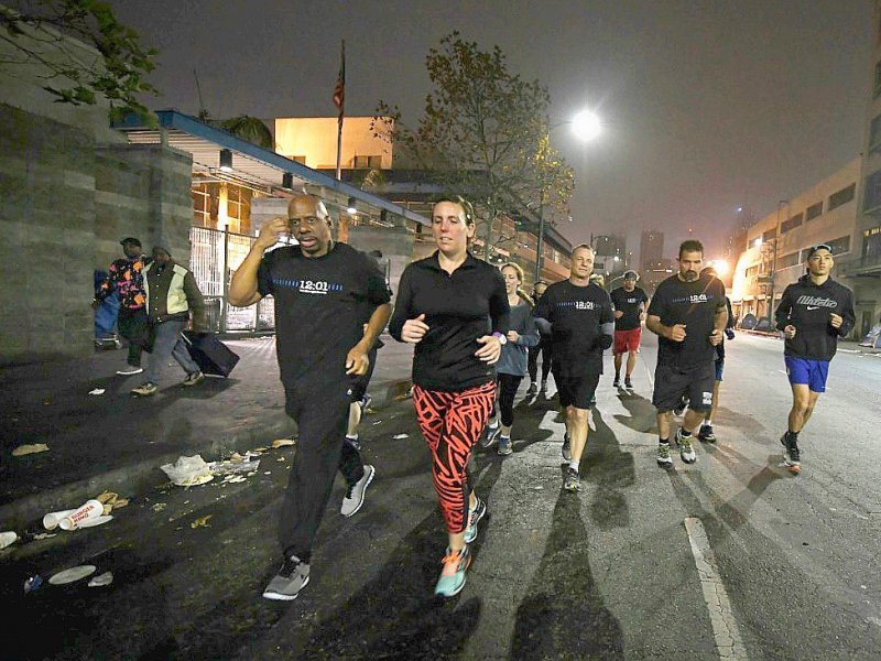 Des joggeurs de Midnight Runners dans les rues du quartier de Skid Row à Los Angeles, le 12 décembre 2016 - Mark RALSTON [AFP]