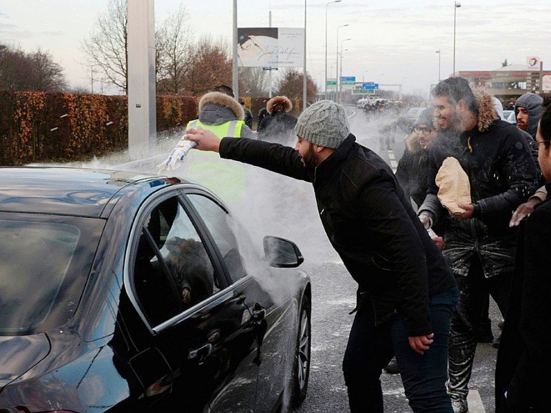 Des VTC grévistes jettent de la farine sur une voiture d'un chauffeur non-gréviste, le 16 décembre 2016 sur l'autoroute reliant Paris à l'aéroport Roissy-Charles-de-Gaulle. - GEOFFROY VAN DER HASSELT [AFP/Archives]