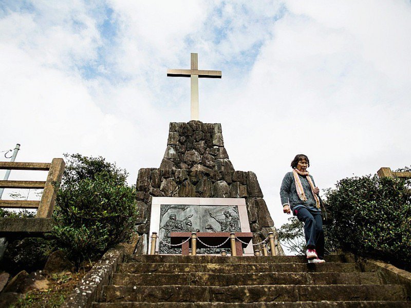 Une femme visite la tombe du chrétien japonais Gaspar Nishi, exécuté en 1609 sur l'île Ikitsuki dans la préfecture de Nagasaki, le 23 novembre 2016 - Behrouz MEHRI [AFP]