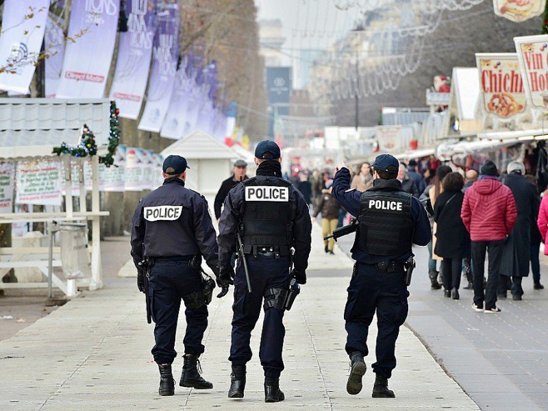 Des policiers  patrouillent le long des échoppes du marché de Noël aux Champs-Élysées à Paris, le 20 décembre 2016 - CHRISTOPHE ARCHAMBAULT [AFP]