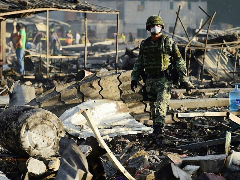 Un homme au milieu des débris calcinés après  l'explosion de feux d'artifice, le 20 décembre 2016 à Mexico - RONALDO SCHEMIDT [AFP]