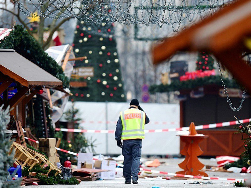 Un policier marche le 20 décembre 2016 dans le marché de Noël près de l'église du Souvenir à Berlin, frappé par un attentat terroriste la veille - Tobias SCHWARZ [AFP]