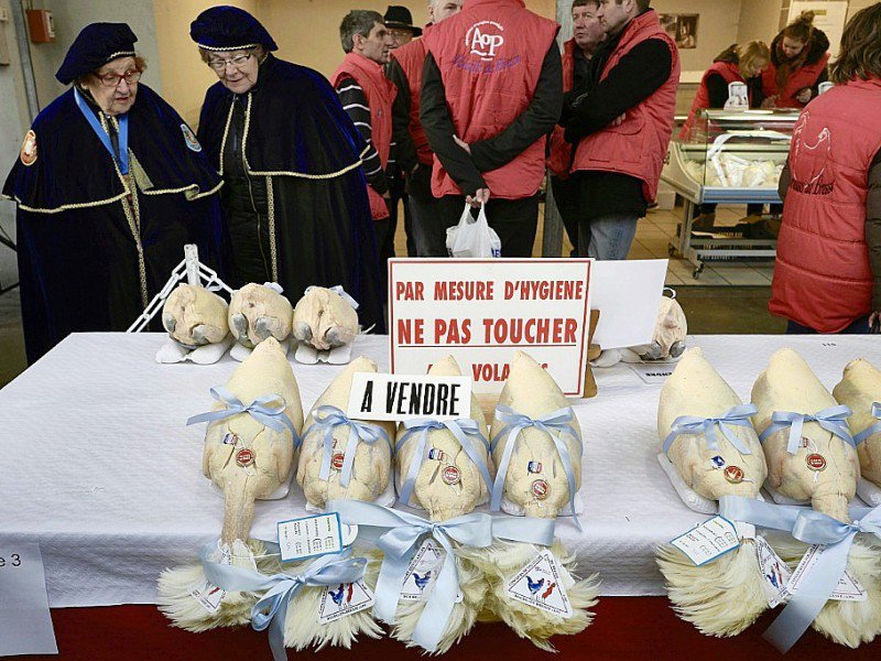 Des gens regardent des volailles sur un marché de Bourg-en-Bresse pendant le concours "Les Glorieuses of Bresse" le 16 décembre 2016 - JEAN-PHILIPPE KSIAZEK [AFP]