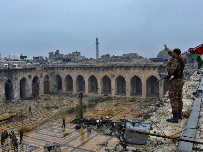 Un soldat pro-régime fait le signe de la victoire au-dessus  de la mosquée des Omeyades dévastée à Alep, le 13 décembre 2016. - George OURFALIAN [AFP/Archives]