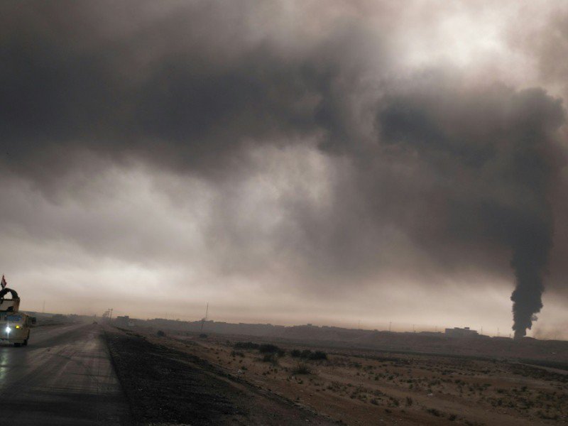Un véhicule de l'armée irakienne emprunte une route près de Mossoul, sous la fumée d'un puits de pétrole enflammé par l'EI, le 4 novembre 2016. - Ahmad MOUSA [AFP/Archives]