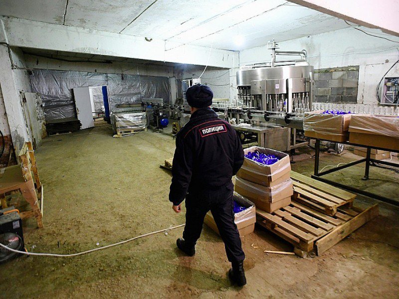 Un policier dans une distillerie illégale de vodka à Koutchki, près de Moscou, le 25 novembre 2016 - Kirill KUDRYAVTSEV [AFP]