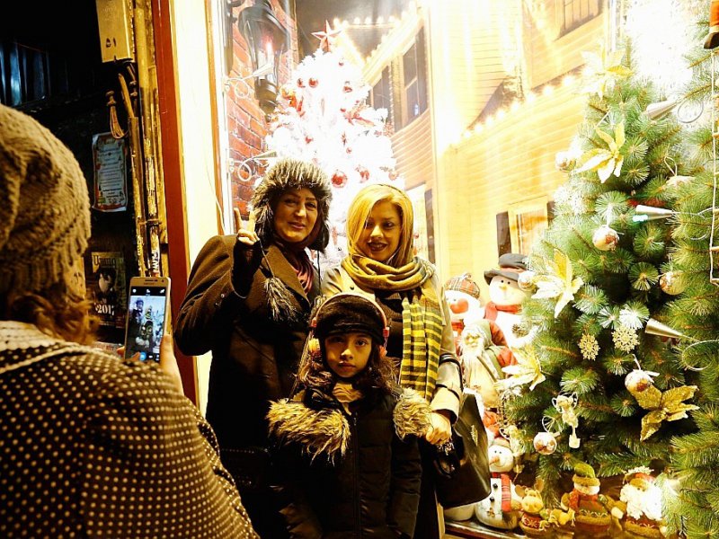 Des Iraniennes se font prendre en photo devant une vitrine de décorations de Noël, le 24 décembre 2016 à Téhéran - ATTA KENARE [AFP]