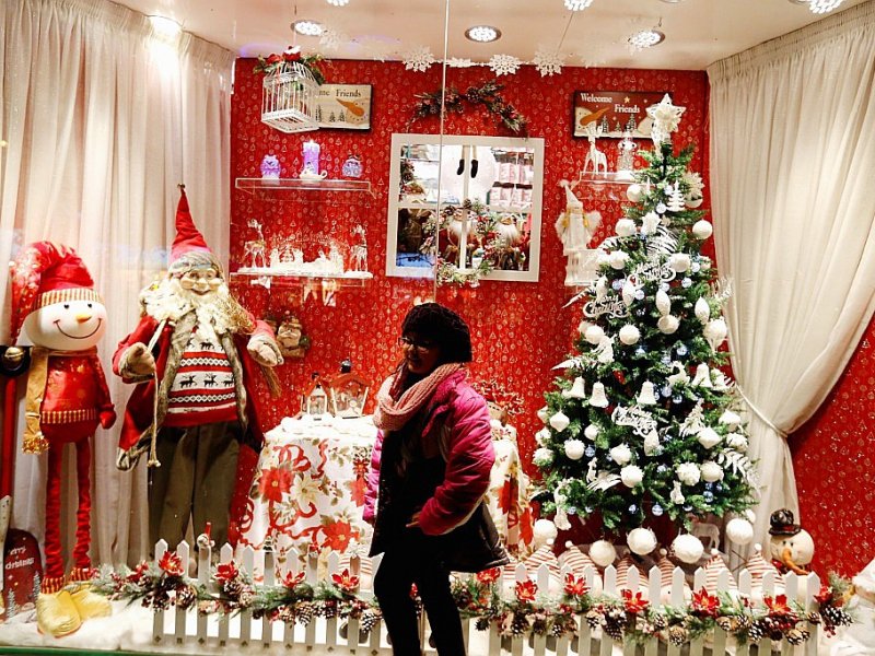 Une Iranienne se fait prendre en photo devant une vitrine de décorations de Noël, le 24 décembre 2016 à Téhéran - ATTA KENARE [AFP]