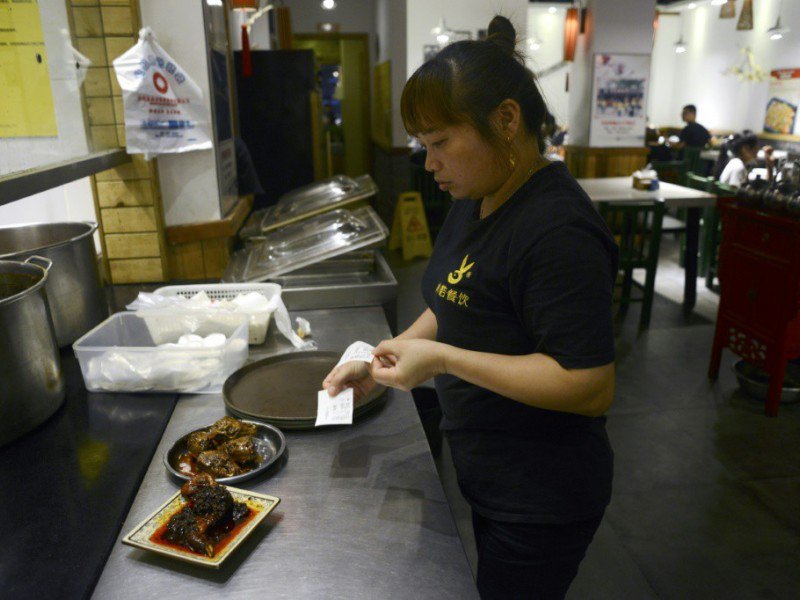 Une serveuse prépare des  têtes de lapîn  le 8 septembre 2016 dans un restaurant de Chengdu en Chine - WANG ZHAO [AFP]