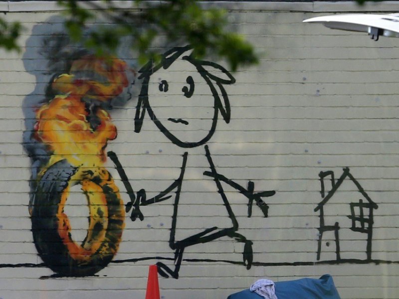 Une oeuvre de l'artiste Banksy sur le mur de son ancienne école à Bristol, en Angleterre, le 7 juin 2016 - GEOFF CADDICK [AFP/Archives]