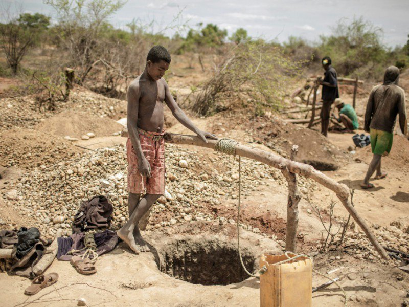 Des mineurs malgaches près des trous où ils vont s'engouffrer à la recherche de saphirs, le  2 décembre 2016, dans les environs de Sakaraha - GIANLUIGI GUERCIA [AFP]