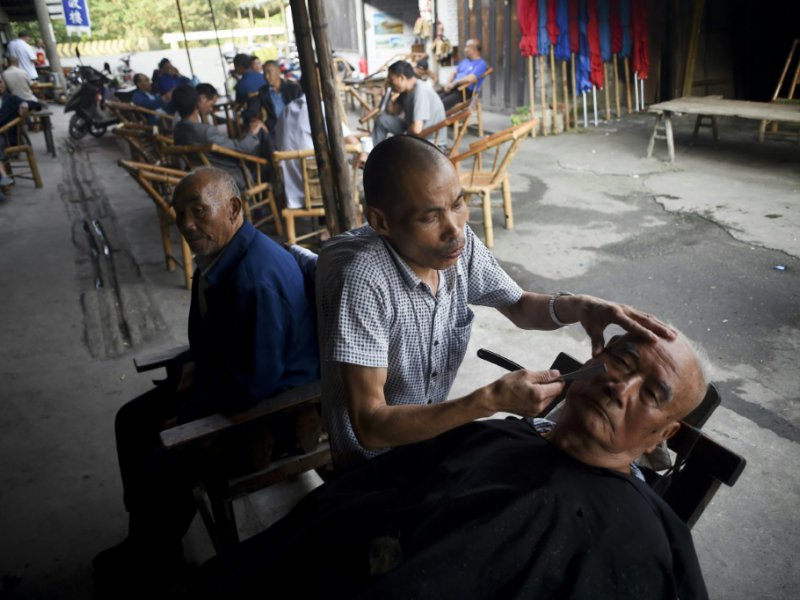 Un barbier en activité près de la célèbre maison de thé de Chengdu, le 11 septembre 2016 - WANG ZHAO [AFP]