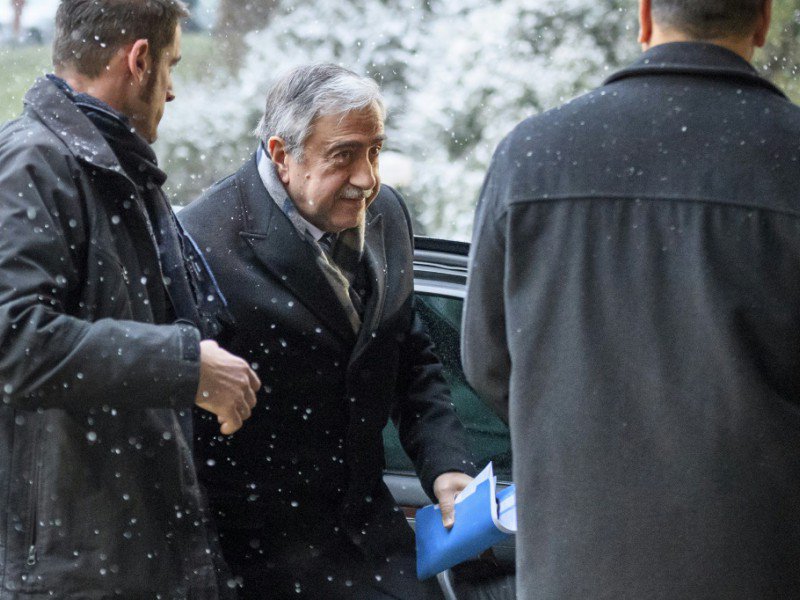 Le dirigeant chypriote turc Mustafa Akinci (c) arrive pour le 2e jour de négociations pour la réunification de l'île, le 10 janvier 2017 à Genève - FABRICE COFFRINI [AFP]